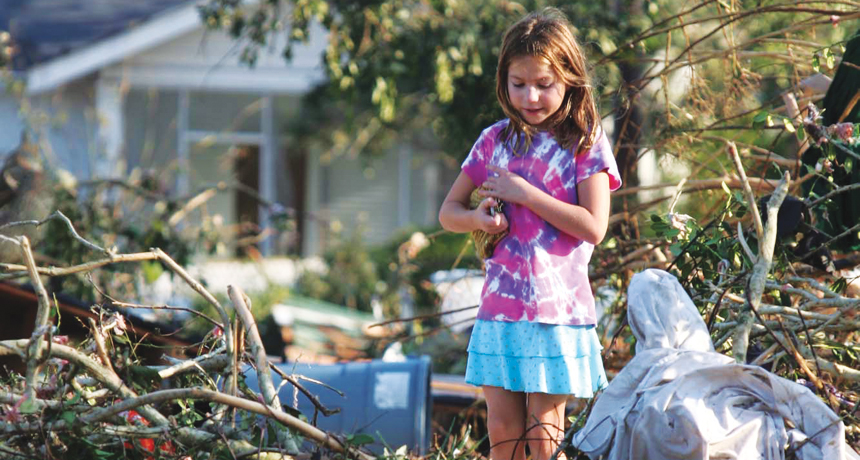 girl standing in wreckage of Hurricane Katrina