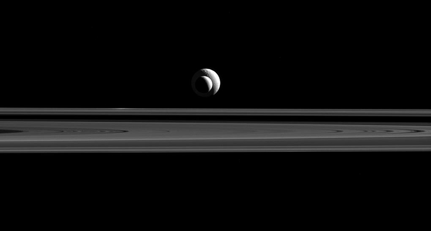 Cassini image of Enceladus over Saturn's rings