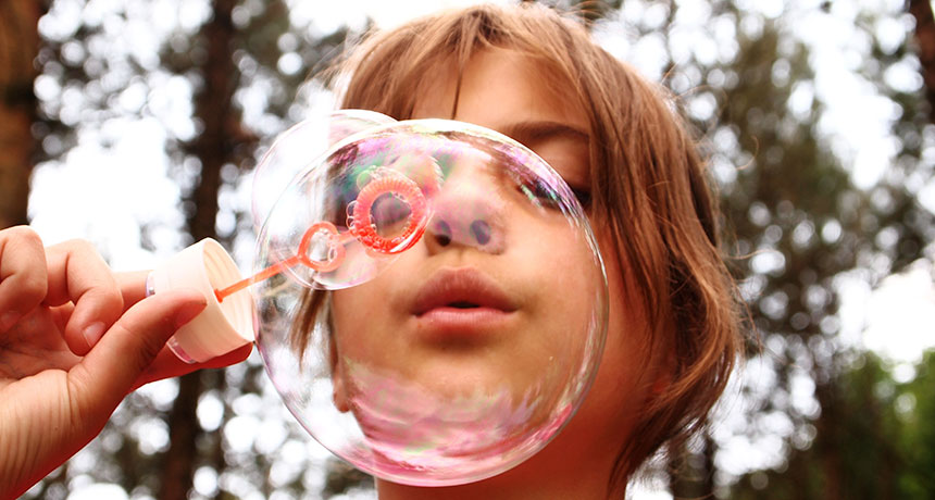 child blowing a bubble