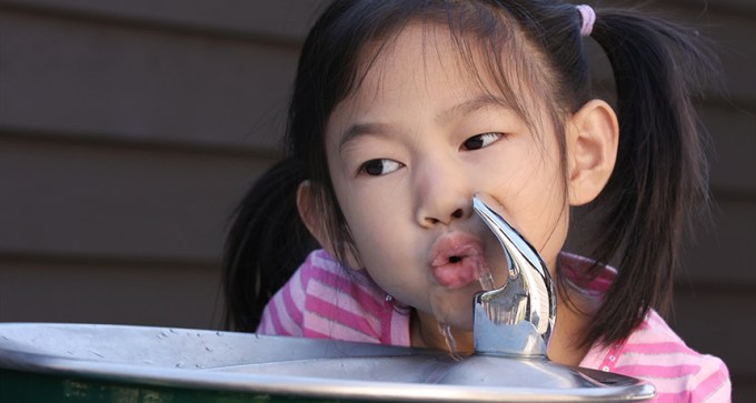 girl drinking from fountain
