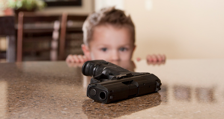 child looking at firearm