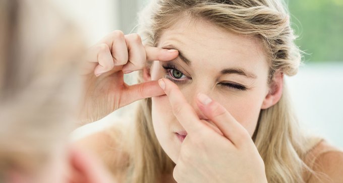 woman putting in contact lens