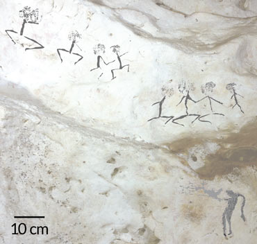 a photo of human figures painted on a cave wall in Borneo