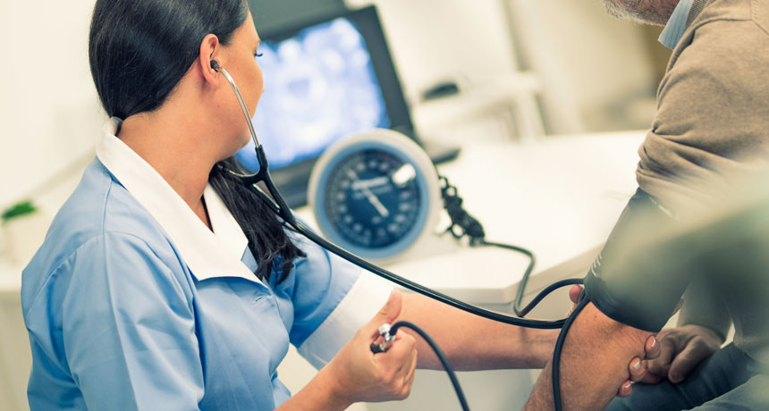 woman checking patient's blood pressure
