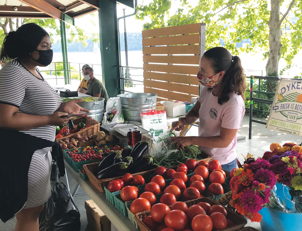 a photo of people at a farmer's market, everyone is wearing face masks