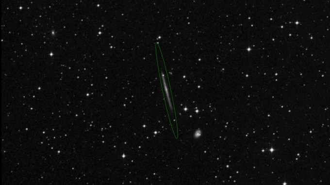 A photo of stars with Galaxy IC 5249 in the center with a green oval around it.