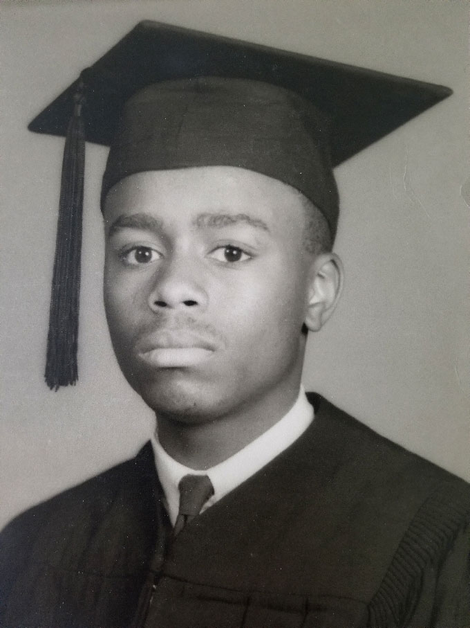 black and white photo of Sekazi Mtingwa in his high school graduation gown and cap