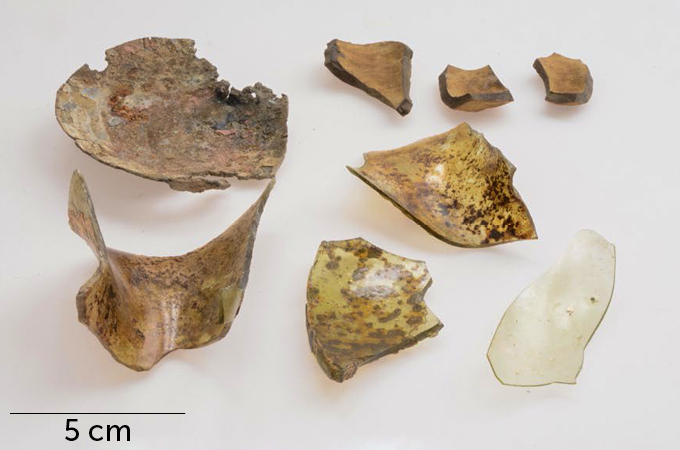Several glass and ceramic shards, most heavily stained brown