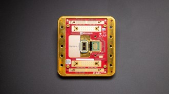 A square, red and metallic device labeled "Majorana 1" sits on a gray background.