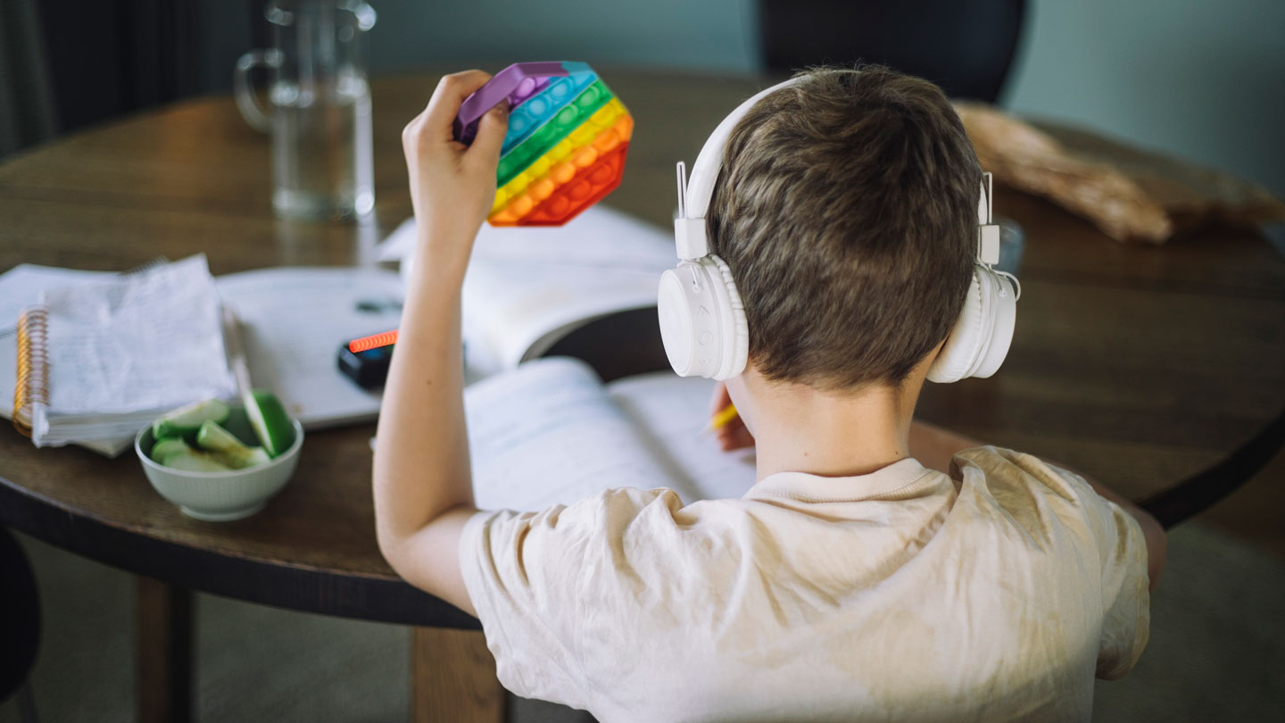 A child wearing headphones plays with colored blocks